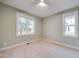 Inviting bedroom with plush carpet and two bright windows that fill the room with natural light at 608 Hemlock Ave, Durham, NC 27707