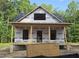 Exterior view of home under construction, showing framing and structure with porch and forested background at 608 Hemlock Ave, Durham, NC 27707