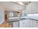 Well-lit kitchen showcasing stainless steel sink, white cabinets, and open view to dining and living spaces at 608 Hemlock Ave, Durham, NC 27707