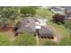 Aerial view of a stone house with well-maintained landscaping and a circular driveway at 609 W Main St, Benson, NC 27504
