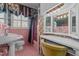 Vintage pink bathroom with pedestal sink, floral wallpaper and natural light at 609 W Main St, Benson, NC 27504