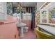 Vintage pink bathroom with floral wallpaper, chandelier, and pedestal sink at 609 W Main St, Benson, NC 27504