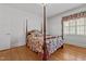 Comfortable bedroom featuring a four-poster bed, wood floors, and bright natural light at 609 W Main St, Benson, NC 27504