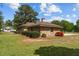 Beautiful home exterior featuring stone facade, mature trees, and a separate garage building at 609 W Main St, Benson, NC 27504