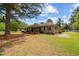 Well-maintained home exterior featuring stone facade, manicured lawn, and mature trees at 609 W Main St, Benson, NC 27504