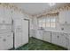 Classic kitchen featuring white appliances and cabinets, plus a window for natural light at 609 W Main St, Benson, NC 27504