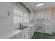 Well-lit kitchen features white countertops and cabinets, plus a double basin sink at 609 W Main St, Benson, NC 27504