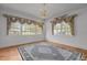Bright living room featuring hardwood floors, large windows, and an elegant chandelier at 609 W Main St, Benson, NC 27504