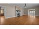 Open living area featuring hardwood floors, a fireplace, and access to additional rooms at 609 W Main St, Benson, NC 27504