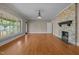Open living area featuring hardwood floors, large windows, and a stone fireplace at 609 W Main St, Benson, NC 27504