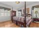 Spacious bedroom featuring a four-poster bed, hardwood floors, and plenty of natural light at 609 W Main St, Benson, NC 27504