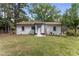 The backyard features a well-maintained lawn surrounded by lush trees, offering a serene outdoor space at 711 Horton Rd, Durham, NC 27704