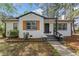 Charming white brick home with black trim, shutters, and a landscaped front yard at 711 Horton Rd, Durham, NC 27704