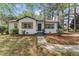 Charming white brick home with black trim, shutters, and a landscaped front yard at 711 Horton Rd, Durham, NC 27704