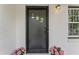 Elegant black front door with accent windows and blooming pink flowers, enhancing curb appeal at 711 Horton Rd, Durham, NC 27704