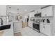 Open concept kitchen with stainless steel appliances, white cabinets, and view to the dining room at 711 Horton Rd, Durham, NC 27704