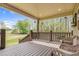 Relaxing back porch with ample seating, a wooden floor, and scenic views of the expansive backyard and lush trees at 93 Clifton Pond Rd, Louisburg, NC 27549