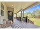 Spacious back porch with outdoor seating and stunning views of the expansive, well-maintained backyard and mature trees at 93 Clifton Pond Rd, Louisburg, NC 27549