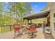 Outdoor wooden deck with covered seating area, perfect for relaxing and enjoying the wooded surroundings at 93 Clifton Pond Rd, Louisburg, NC 27549