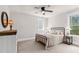 Neutral bedroom with carpet flooring, ceiling fan, a window, and a black metal bed frame at 93 Clifton Pond Rd, Louisburg, NC 27549
