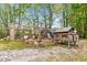 Outdoor chicken coop with mature trees, surrounding fence and gravel walkway at 93 Clifton Pond Rd, Louisburg, NC 27549