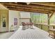 Inviting outdoor deck area with wood floors, seating, and exposed beam ceiling at 93 Clifton Pond Rd, Louisburg, NC 27549