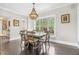 Cozy dining room with wood floors, large windows, and a stylish chandelier at 93 Clifton Pond Rd, Louisburg, NC 27549