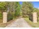 Grand entrance with stone pillars and iron gates, leading to a private drive, providing security and a touch of elegance at 93 Clifton Pond Rd, Louisburg, NC 27549