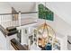 Open-concept foyer with a statement light fixture, bookshelf, and railing overlooking the living area at 93 Clifton Pond Rd, Louisburg, NC 27549
