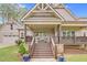 Charming front porch with stone accents, wooden railings, and comfortable seating overlooking a landscaped yard at 93 Clifton Pond Rd, Louisburg, NC 27549