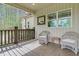 Inviting front porch featuring wicker chairs, a small table, and views of the home's exterior and surrounding greenery at 93 Clifton Pond Rd, Louisburg, NC 27549