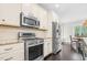 Kitchen features stainless steel appliances, white cabinetry, and a view to the dining area at 93 Clifton Pond Rd, Louisburg, NC 27549