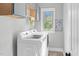 Functional laundry room featuring modern appliances, a bright window, and storage cabinets, offering convenience at 93 Clifton Pond Rd, Louisburg, NC 27549