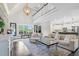 Open-concept living area with a view of the kitchen, featuring a chic area rug and large windows at 93 Clifton Pond Rd, Louisburg, NC 27549