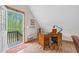 Upstairs office space with wooden desk and natural light from the outdoor balcony at 93 Clifton Pond Rd, Louisburg, NC 27549