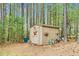 A storage shed is nestled in a backyard landscape at 93 Clifton Pond Rd, Louisburg, NC 27549