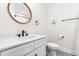 Well-lit bathroom features a circular mirror, single sink vanity, and modern fixtures at 95 Watermeadow Dr, Clayton, NC 27520