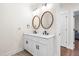 Elegant bathroom with double sink vanity, modern fixtures, and a stylish oval mirror, creating a serene space at 95 Watermeadow Dr, Clayton, NC 27520