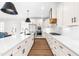 Modern kitchen featuring white cabinets, stainless steel appliances, a large island, and hardwood floors at 95 Watermeadow Dr, Clayton, NC 27520