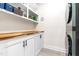 Bright laundry room featuring white cabinets with a wooden countertop and stackable washer and dryer unit at 95 Watermeadow Dr, Clayton, NC 27520