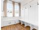 Bright mudroom with built-in bench, cabinets, and coat hooks; laminate flooring and window at 95 Watermeadow Dr, Clayton, NC 27520