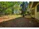 The back of the home featuring a deck, and a lawn surrounded by mature trees at 103 Windhover Dr, Chapel Hill, NC 27514
