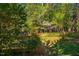 The back of the home featuring a deck, and a lawn surrounded by mature trees at 103 Windhover Dr, Chapel Hill, NC 27514