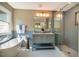 Elegant bathroom featuring a soaking tub, a walk-in glass shower, and a double vanity with modern fixtures at 103 Windhover Dr, Chapel Hill, NC 27514