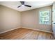 A cozy bedroom featuring hardwood floors, a ceiling fan and natural light from the window at 103 Windhover Dr, Chapel Hill, NC 27514