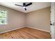Simple bedroom features hardwood floors, a ceiling fan, and a single window with views of the outside at 103 Windhover Dr, Chapel Hill, NC 27514