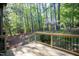 A wooden deck with black metal railings overlooks a backyard filled with a variety of trees at 103 Windhover Dr, Chapel Hill, NC 27514