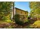 The back of the home featuring a deck, and a lawn surrounded by mature trees at 103 Windhover Dr, Chapel Hill, NC 27514