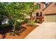 Beautiful brick home with manicured landscaping, flowering trees, and a spacious driveway leading to a two-car garage at 103 Windhover Dr, Chapel Hill, NC 27514