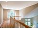 Bright hallway featuring hardwood floors, a wooden banister, and multiple windows providing ample natural light at 103 Windhover Dr, Chapel Hill, NC 27514